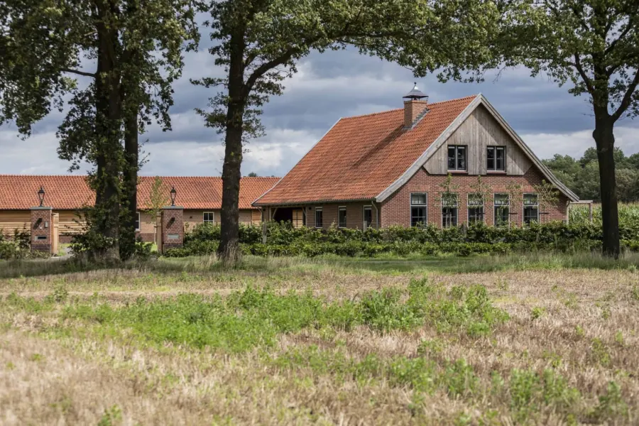 Vakantieboerderij 't Onland gezien vanaf het weiland tussen de eiken