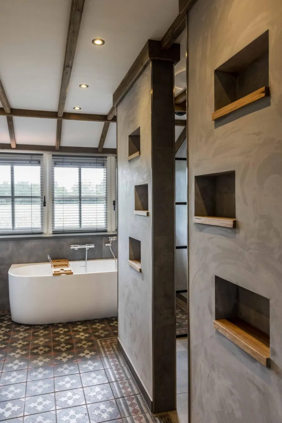 Badkamer met vrijstaand ligbad en betonstuc wanden