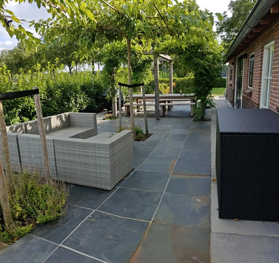Loungeset op het terras onder de begroeide pergola